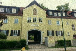 Gemaltes Bild eines gelben Gebäudes mit Torbogen